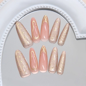 French pink cat-eye stiletto press-on nails with gold embossed edges and 3D sunset effect