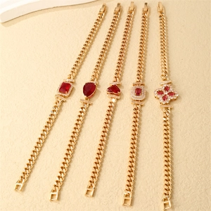 Detailed close-up of gold Cuban link bracelets with various red gemstone pendants