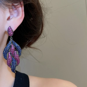 Detail of luxury pink and blue zircon drop earrings in vintage black gold plating on model