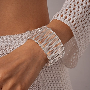 Detailed view of wide silver metal cuff bracelet featuring a layered wire mesh design