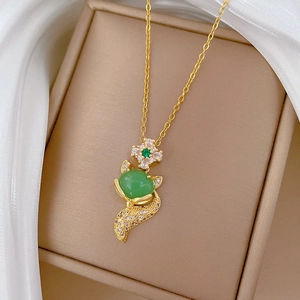 Elegant gold titanium fox necklace featuring a large oval green stone and zircon crystals