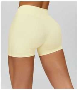 Dettaglio degli shorts da yoga giallo tenue a vita alta con cuciture piatte e vestibilità