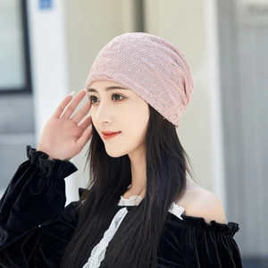 Close-up of the delicate pink lace texture with shimmering rhinestones on the beanie hat