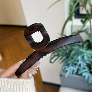 Detail of tortoise shell patterned hair claw clip with square cutout handle and spring