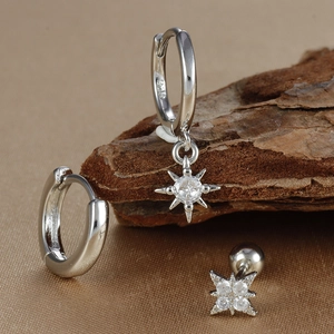 Macro shot of silver S925 earrings with sparkling star pendants and clear zircons