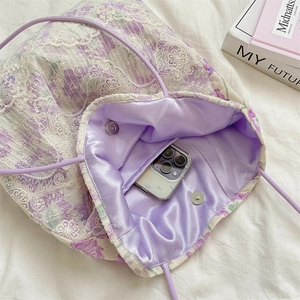 Detail of purple floral lace tote bag interior with magnetic closure and phone pocket