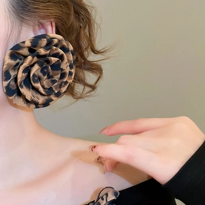 Close-up of model wearing leopard print fabric flower earrings with a vintage touch