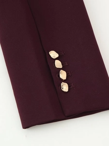 Makroaufnahme der weinroten Blazer-Manschetten mit vier goldenen Metallic-Knöpfen