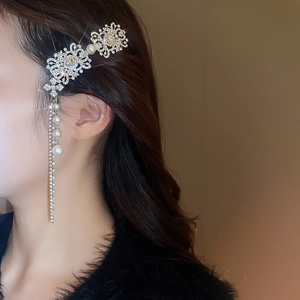 Detail of vintage silver hair clip with sparkling diamonds and elegant pearl tassels