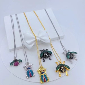 Detailed view of copper-plated beetle pendants with inlaid zircons and colorful crystals