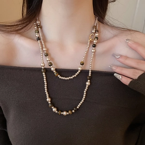 Dettaglio della collana a doppio strato con pietre occhio di tigre e perline metalliche dorate