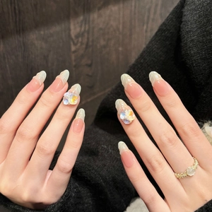 Detail of long almond press-on nails with iridescent rhinestones and marble tips