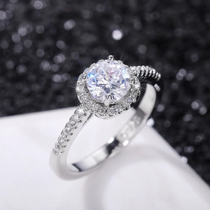 Macro shot of silver halo ring featuring round cut center stone and pavé diamond band