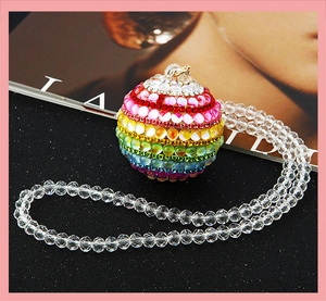 Macro detail of rainbow crystal sphere car pendant and faceted clear bead chain hanging