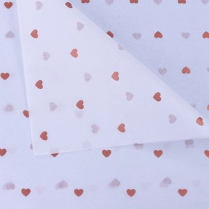 Detail of white tissue wrapping paper with brown heart pattern and translucent texture