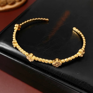 Dettaglio del bracciale placcato oro 18k con motivi a quadrifoglio e bordi a sferette