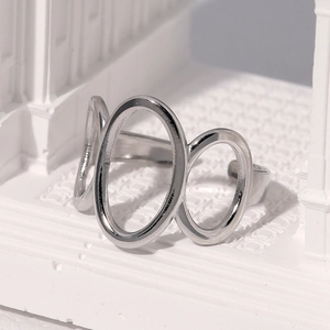 Minimalist silver triple oval stainless steel open ring displayed on architectural props
