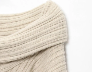 Close-up of beige ribbed knit sweater showing soft texture and vertical stripe pattern