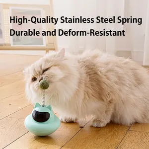 Mint green tumbler cat toy with suction cup and steel spring shown with a playful cat
