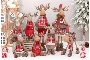 Close-up of red and brown plaid Christmas reindeer plush dolls in festive winter setting