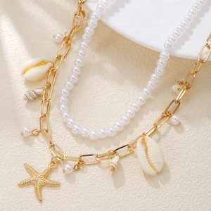 Close-up of double-layered ocean necklace with starfish, shells and pearls on stone surface