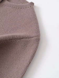 Vue macro détaillée de la maille fine taupe et de la couture soignée de l'encolure