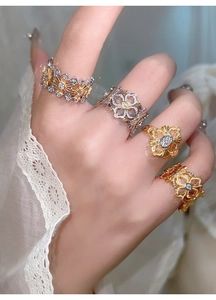 Détail de bagues fleurs en or et argent avec zircons et texture en métal brossé