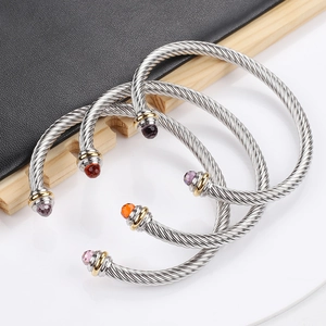 Detailed macro view of silver twisted cable bracelets with colorful faceted gemstones