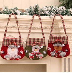 Détail de sacs de Noël avec Père Noël, bonhomme de neige et renne et anses à carreaux