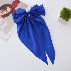 Detail of Klein blue satin bow hair clip with long ribbons and premium silky texture