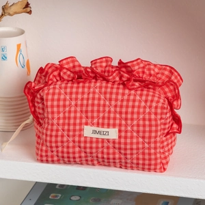 Red and white checkered quilted cotton makeup bag with ruffle trim and zipper closure