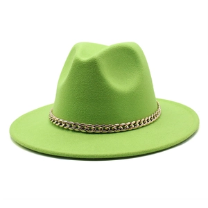 Detail of bright green wool fedora hat featuring a chunky gold chain band accessory
