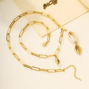 Detail of layered gold necklace featuring natural white shell and golden metallic seashell pendants