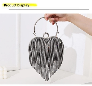 Detail of silver heart-shaped evening bag with shimmering rhinestones and long fringe tassels