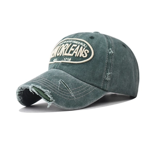 Close-up of vintage washed green baseball cap with distressed embroidery and worn details