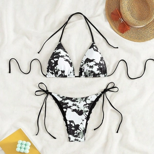 Detailed flat lay of a marble print lace-up bikini with summer beach accessories