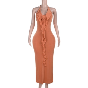 Detail of orange halter dress featuring ruffled neckline and 3D floral accent