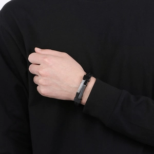 Detail of men's woven leather bracelet with geometric metal buckle worn on wrist