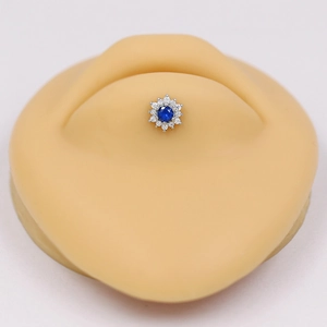 Macro view of blue gemstone flower labret stud on silicone body piercing model
