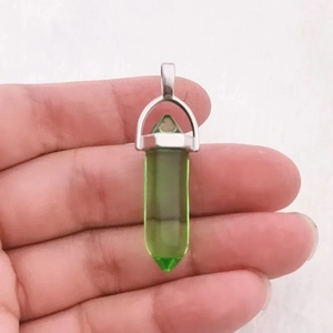 Gedetailleerd macrobeeld van een zeshoekige groene kristallen hanger met zilveren borg