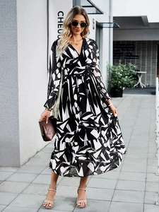 Detail of V-neck long sleeve dress with black and white geometric print and ruffled hem