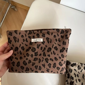 Texture détaillée d'une trousse de maquillage en velours côtelé léopard et étiquette