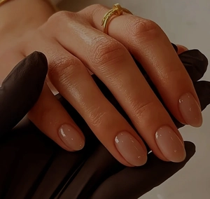 Vista detallada de un anillo envolvente dorado con forma de clavo en un dedo cuidado