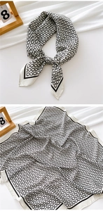Detail of black and white geometric silk scarf with satin finish and chain pattern texture