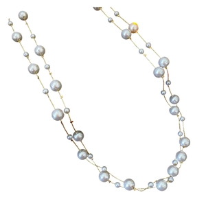 Long vintage pearl necklace with silver-gray pearls and gold chain on white background