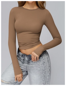 Detail of slim-fit brown long-sleeve sports top with matte elastic fabric texture