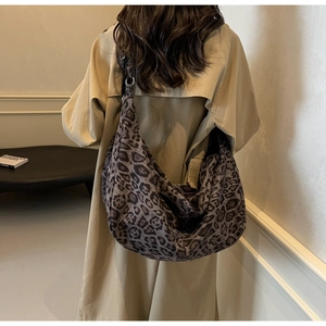 Detailed macro view of large leopard print hobo shoulder bag with soft velvet texture