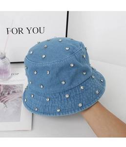 Close-up of sparkling silver rhinestones on the blue washed denim bucket hat material