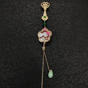 Détail de la broche en éventail avec fleurs de prunier roses, pompons d'or et jade vert