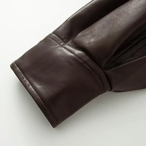 Détail du poignet en cuir marron foncé avec couture à double aiguille de haute précision